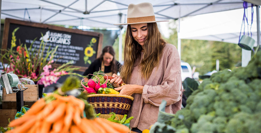 A person in a hat shopping for farm fresh produce at the Whistler Farmers' Market
