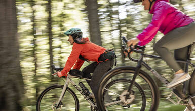 Two people biking through the woods on the Whistler Valley Trail