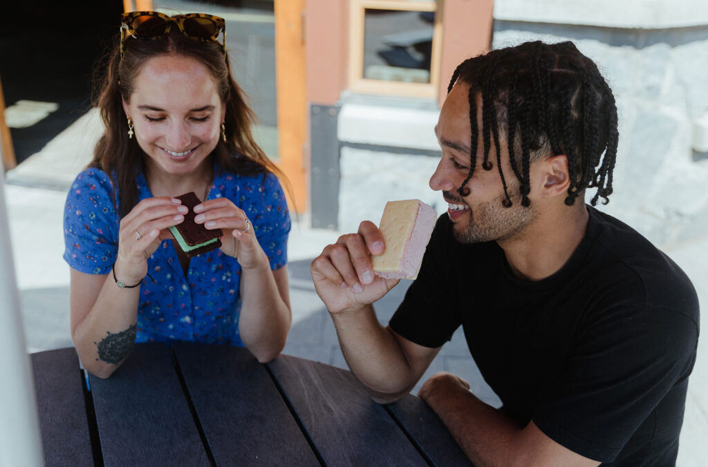 Two people sit at Fix Cafe in Whistler eating ice cream sandwiches.