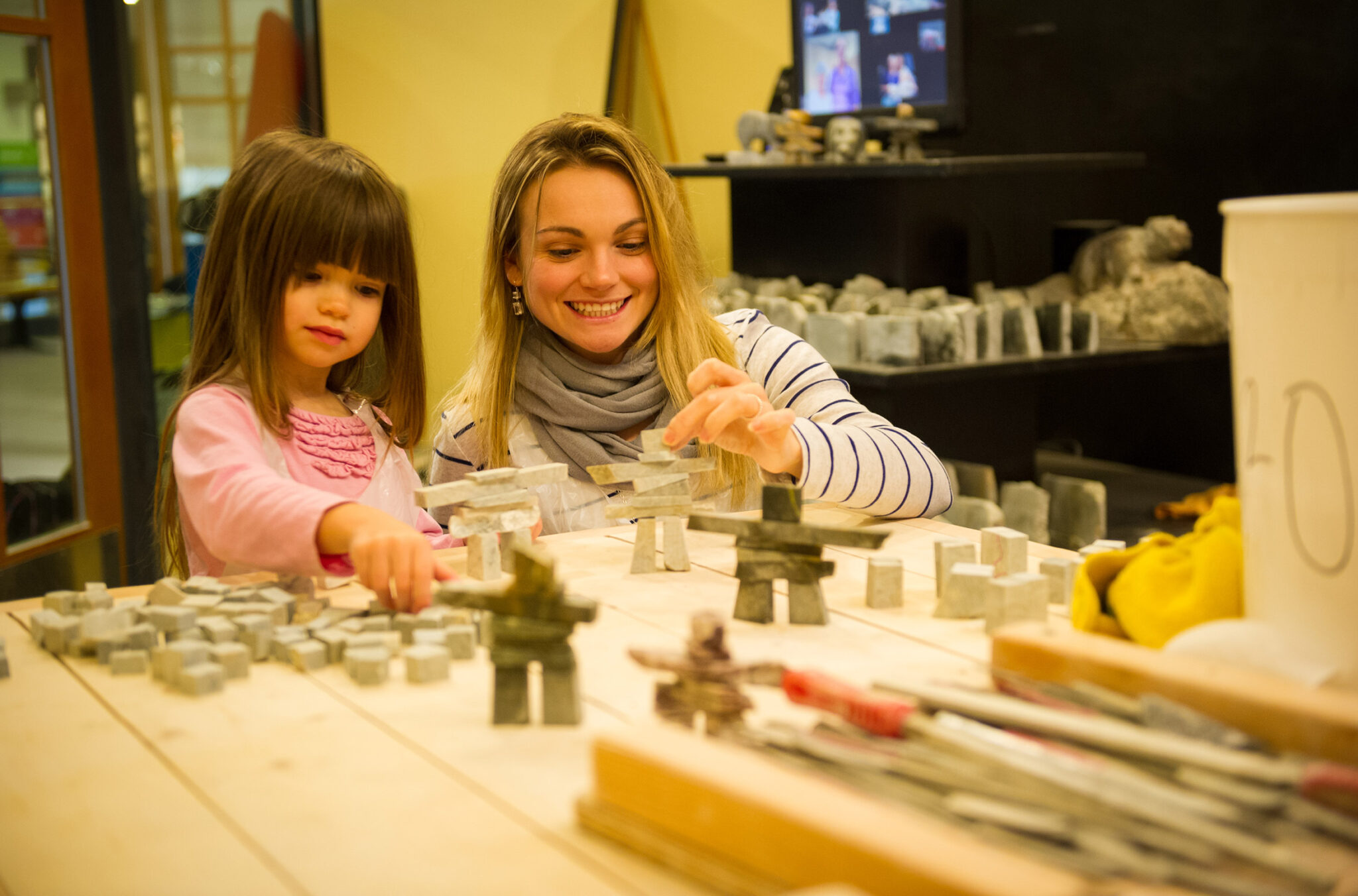 A mother and daughter make a soap stone Inuksuk at the Fathom Stone Art Gallery in Whistler.