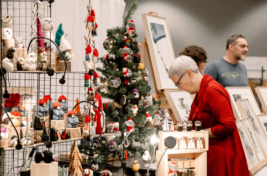 A festive shopper looks at artwork and felt figures at the Arts Whistler Holiday Market in Whistler.