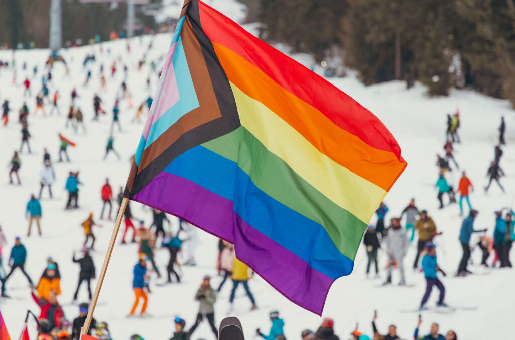 A Pride flag flutters in the breeze as it's carried down Whistler Mountain by people celebrating Whistler Pride and Ski Festival. 