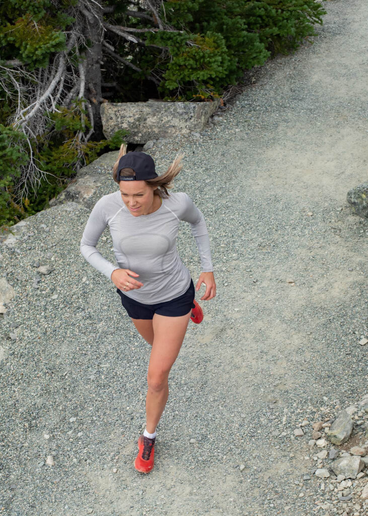 Whistler trail runner Lou O'Brien runs along a gravel path amongst the trees.