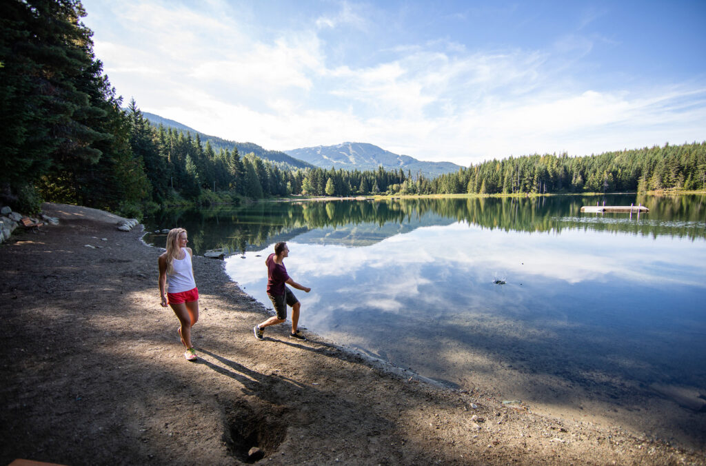 A couple walk down to the waters at Lost Lake Park in Whistler.