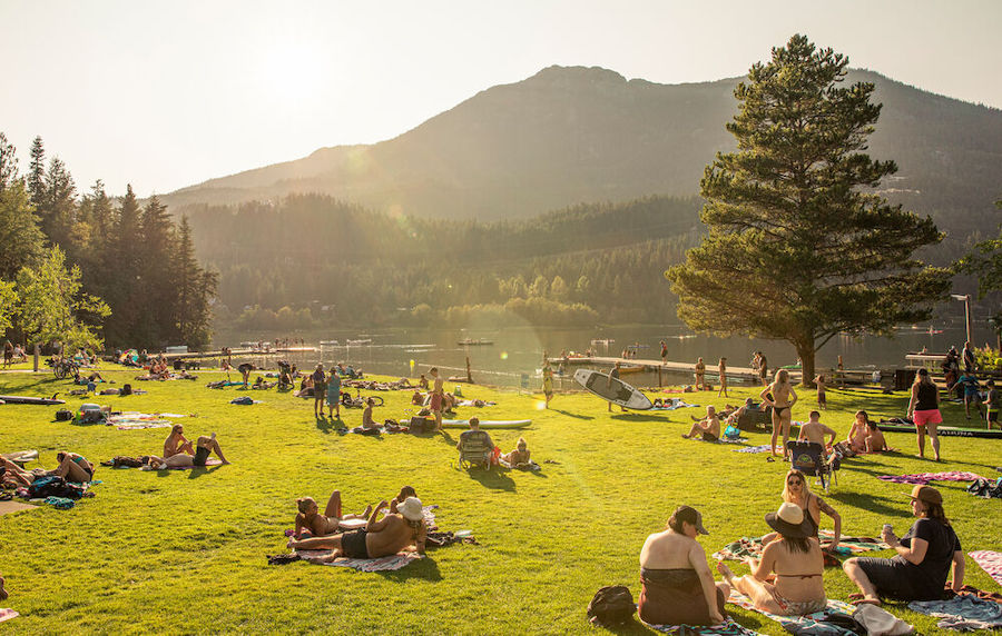 People relax by a lake in Whistler. 