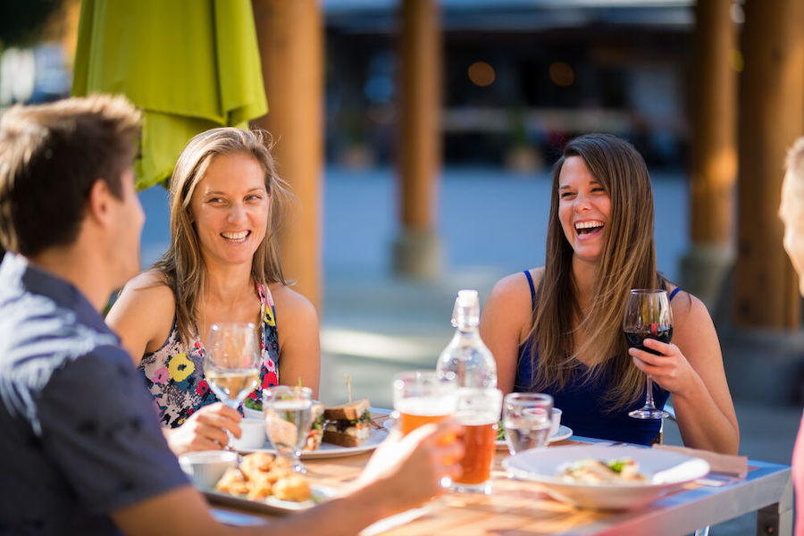 Friends enjoy snacks and drinks on a patio in Whistler. 