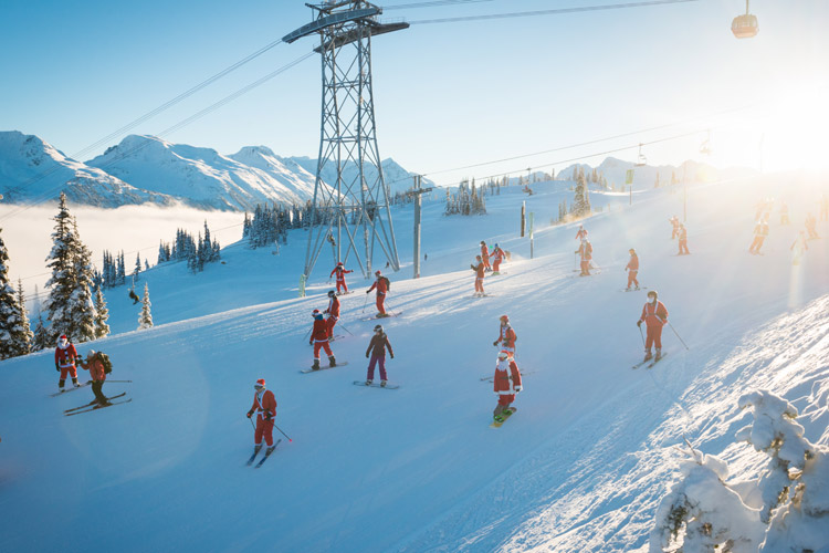 Skiers and snowboarders dressed up as Santa Claus make their way down the slopes of Whistler Blackcomb.