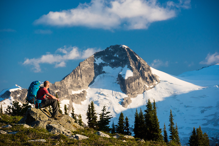 Man sitting on rock staring at mountain in Whistler