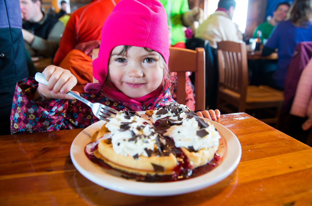  A young girl tucks into a waffle at the Crystal Hut at Whistler Blackcomb.