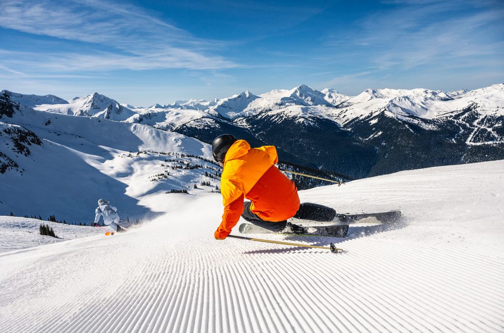 A skier makes their way down a wide, groomed slope in the 7th Heaven area on Whistler Blackcomb.