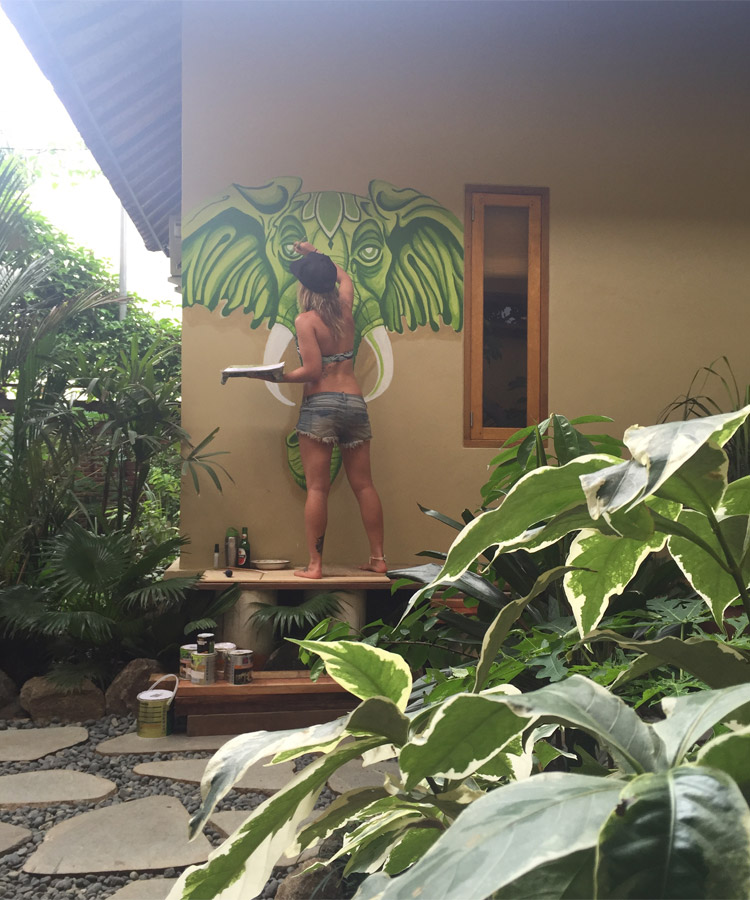 Helen Wojcik painting a mural