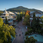A shot of Whistler Village taken from above with the mountains in the background.