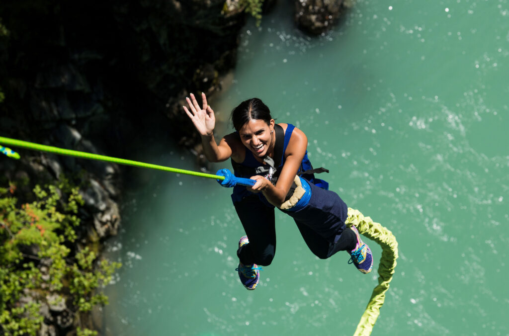 A woman takes a leap of faith bungee jumping over a glacial river in Whistler.
