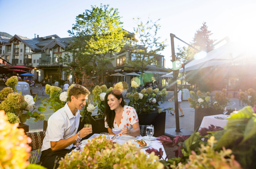 A couple dines on a pretty patio in Whistler Village.