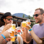 A group of friends raise their glasses in a cheers at the Whistler Village Beer Festival.