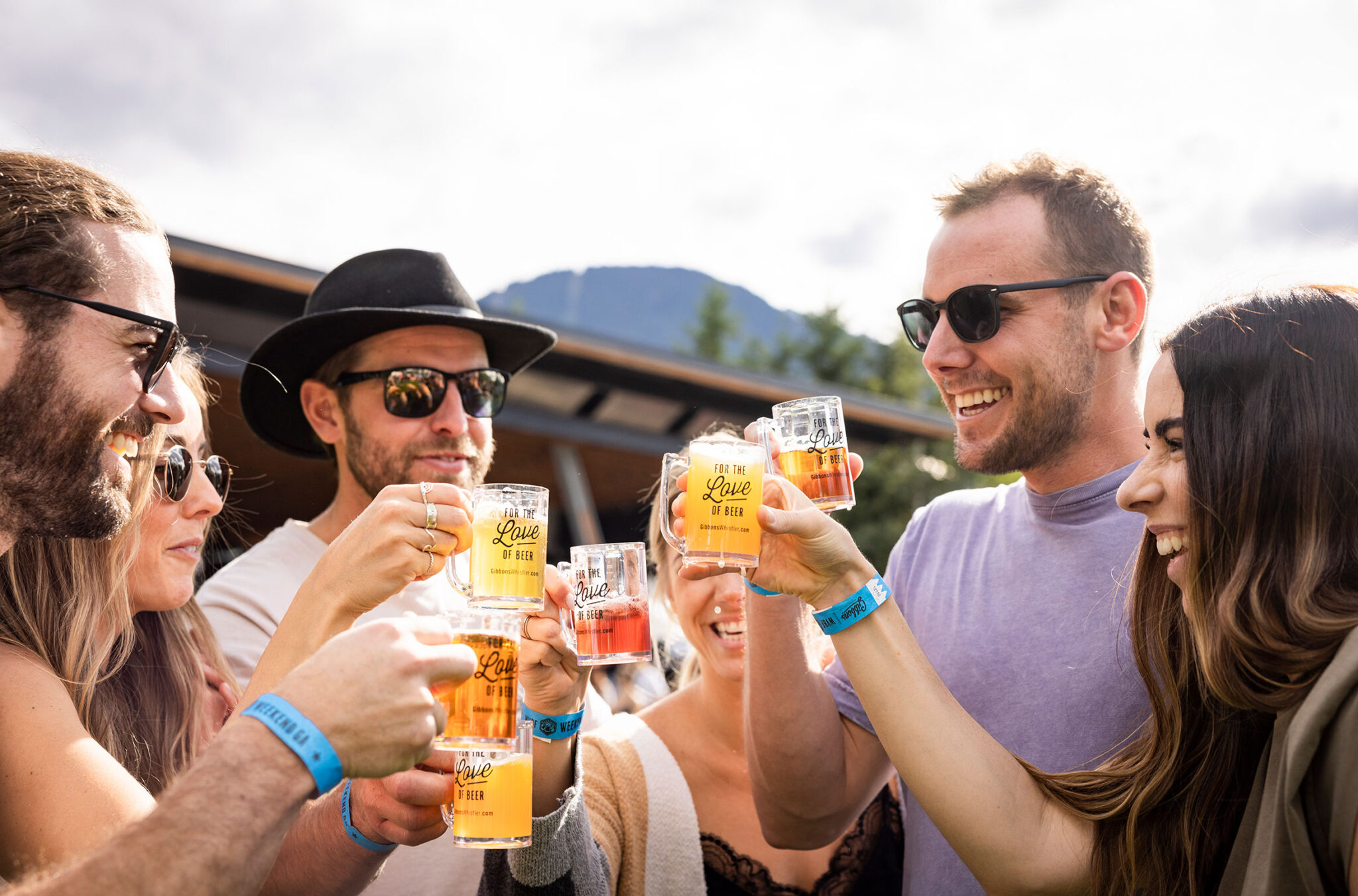 A group of friends raise their glasses in a cheers at the Whistler Village Beer Festival.