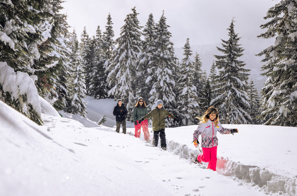 A family snowshoes in the deep snow at Whistler Olympic Park.