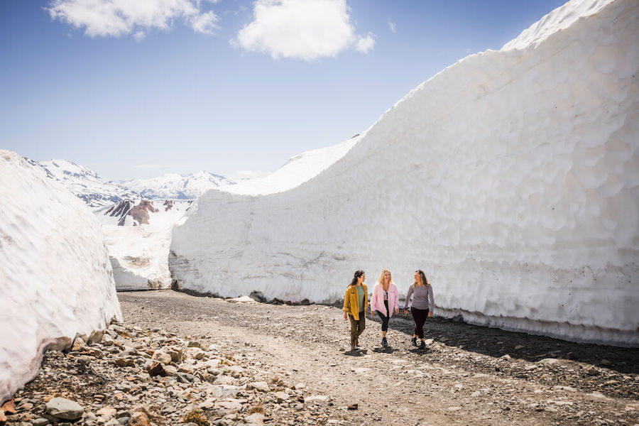Three hikers explore the snow walls on Whistler Mountain. 
