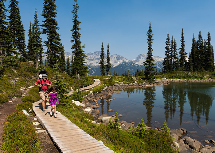 Family hiking on boardwalk around Harmony Lake on Whistler Mountain