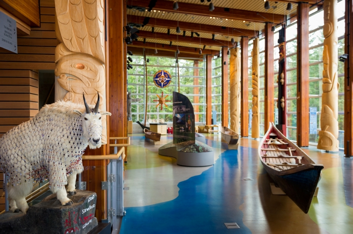 Large room with floor to ceiling windows and native artifacts.