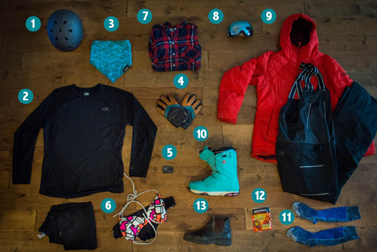 Goods laid out for what to pack for skiing and snowboarding from above.