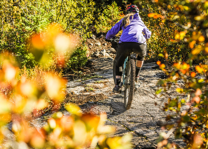 Mountain biker rides over a rock slab on Whistler's Westside trails.