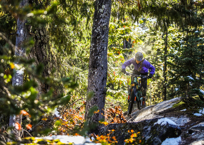 A mountain biker rides through sun and snow on Whistler's West Side trails.