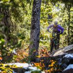 A mountain biker riders through sun and snow on Whistler's West Side trails.