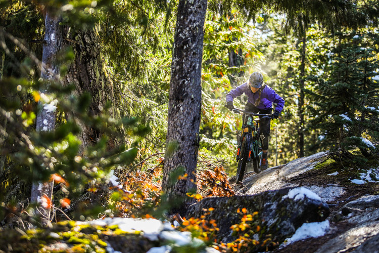 A mountain biker riders through sun and snow on Whistler's West Side trails.