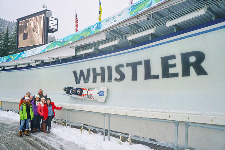 Family posing in front of bobsleigh track in Whistler