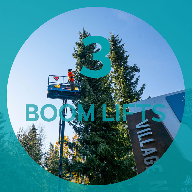 A man on a boom lift strings lights in preparation for Whistler's festive season.