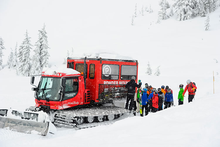 group of people loading into a snowcat on a snowy day