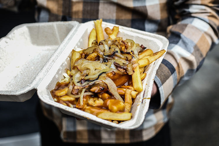 A takeout container piled high with poutine.