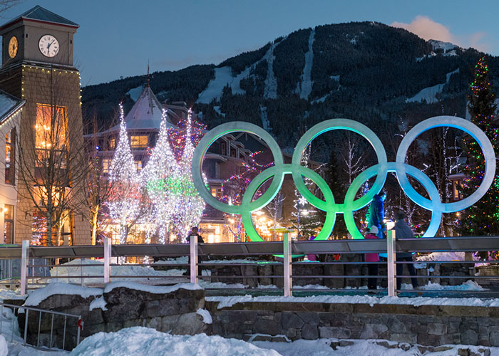 Whistler Village is lit up with festive lights in the trees and glowing Olympic rings.