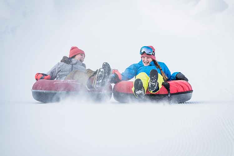 two people tubing on snow