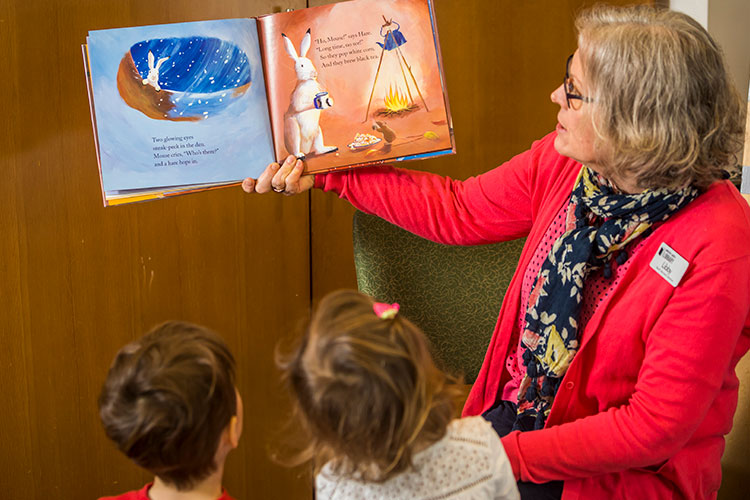 Librarian reading a book to two children at the Whistler Public Library.
