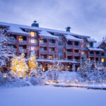 A wintery shot of the snow-clad Nita Lake Lodge as seen from the lake in Creekside.