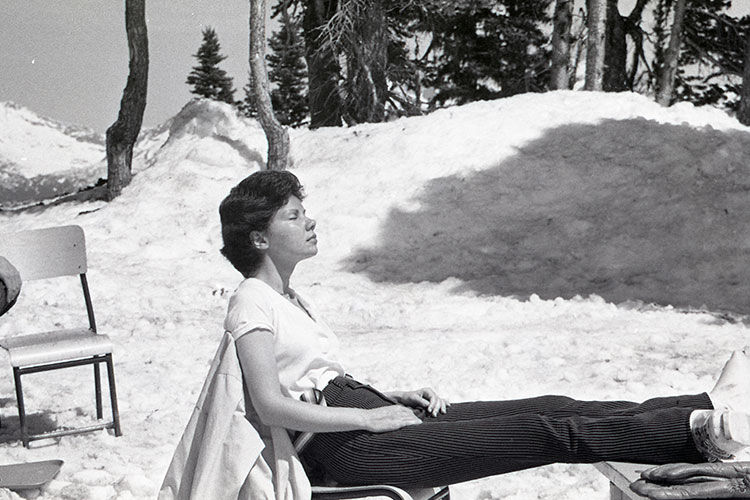 A black and white image of a woman enjoying the sunshine on a chair lift on a spring day in Whistler.