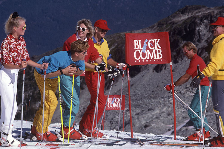 A group of skiers stand in the sun on Blackcomb Mountain.