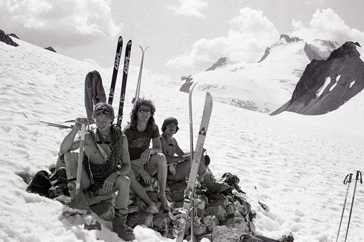 A black and white shot of three male skiers in the backcountry not wearing very much. 