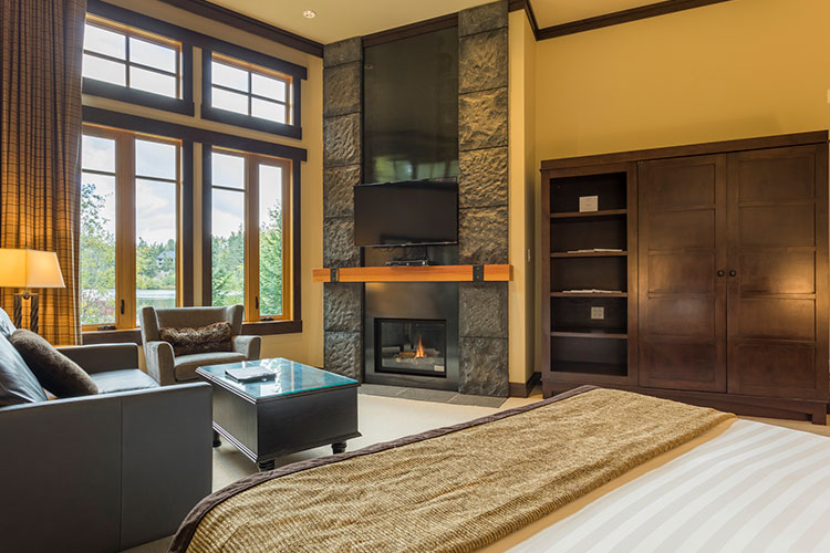 The inside of the Lakeview Studio Suite at Nita Lake Lodge has a fireplace, king bed, and comfy sofas.