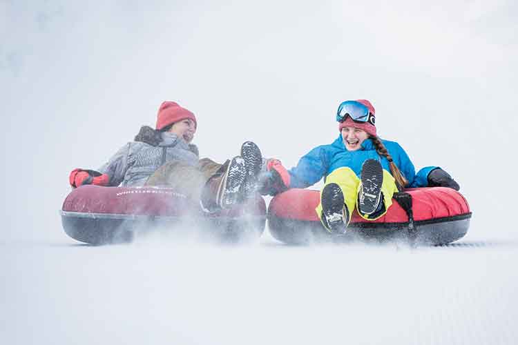 people sliding on tubes 