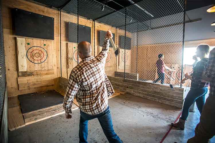 Man throws an axe at a target at this budget friendly activity.