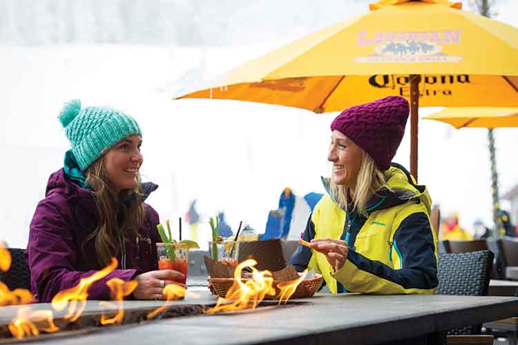 Women enjoying a fireside apres.