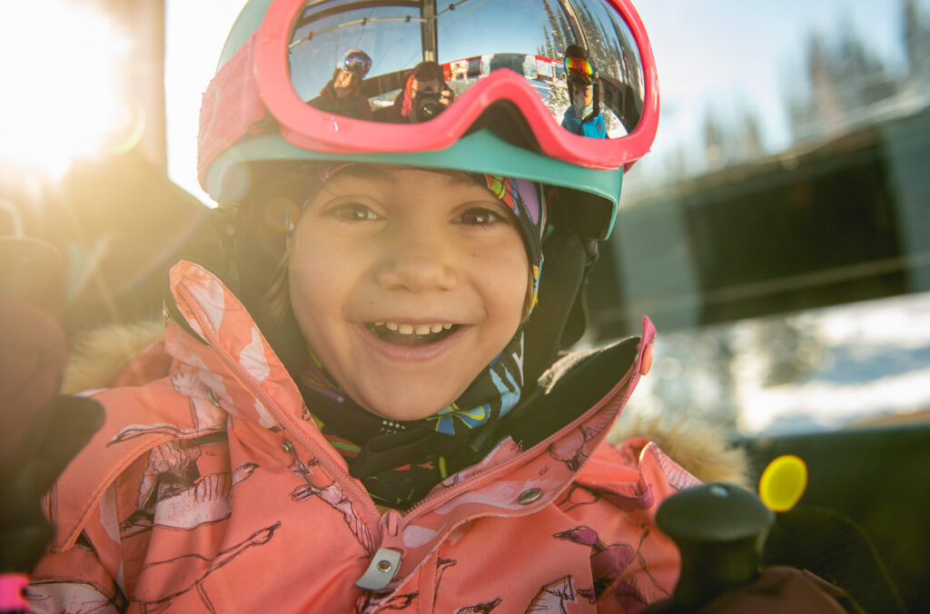 A child smiles directly at the camera on a ski day on Whistler Blackcomb.
