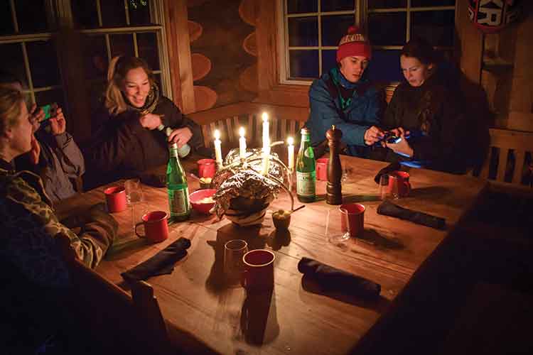 A group gathered around a candle lit table.