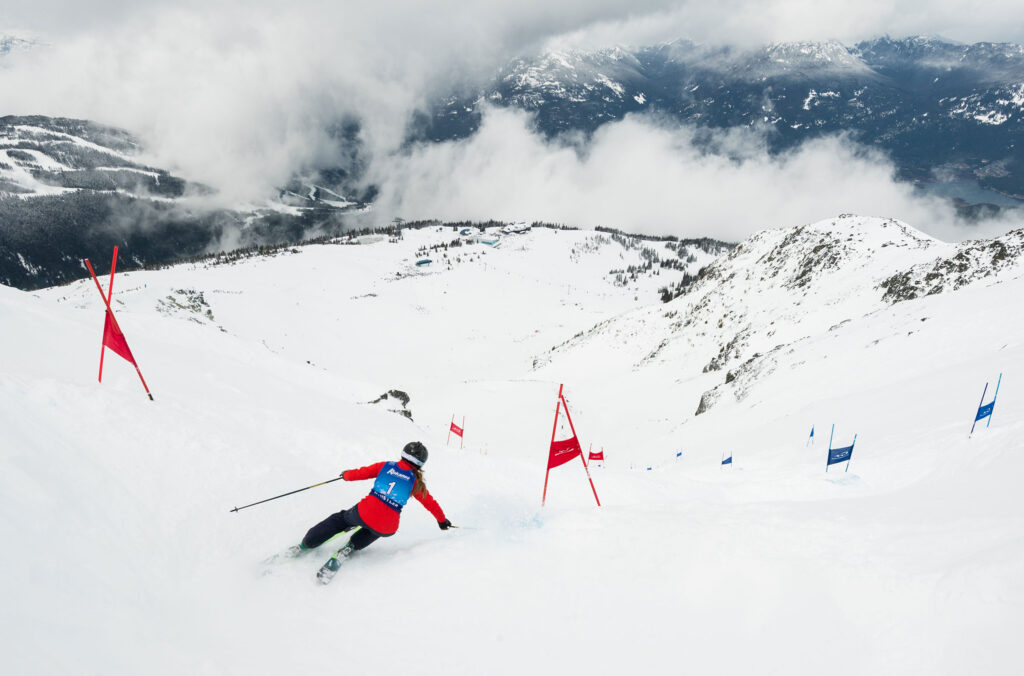 A ski racer makes their way through the gates while racing the Saudan Couloir.