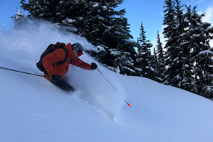 Heli-touring guide skiing in powder