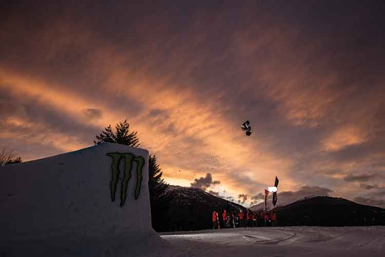 snowboarder going off of a sunset jump