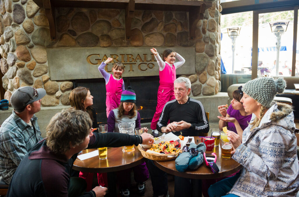 Two kids dance in their ski boots at the Garibaldi Lift Co. in Whistler as their family eats and drinks for apres.